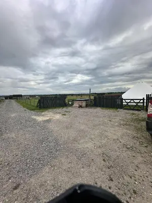 a dirt road with a fence and a tent at Unit 0 - Fully Serviced All Weather Pitch with Hot Tub in Carlisle
