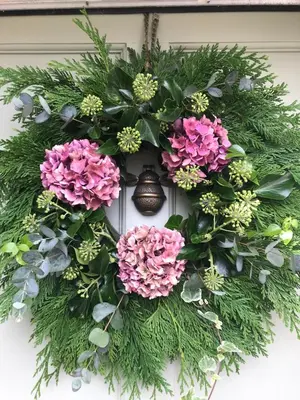a wreath on a door with flowers on it at Evas cottage near Scafell in Gosforth
