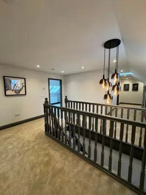 a staircase in a home with a chandelier at Rumblekirn in Annan
