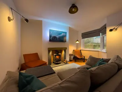 a living room with a couch and a fireplace at Coastal Lakes Mews Cottage