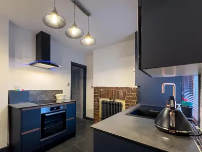a kitchen with blue cabinets and a sink at Coastal Lakes Mews Cottage