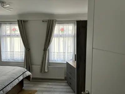 a bedroom with two windows and a bed and a dresser at Favourland Home in Moffat