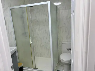 a bathroom with a toilet and a glass shower at Favourland Home in Moffat