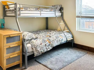 a bedroom with two bunk beds and a desk at Miner's Rest in Frizington