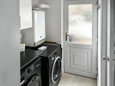 a laundry room with a washing machine and a window at Miner's Rest in Frizington