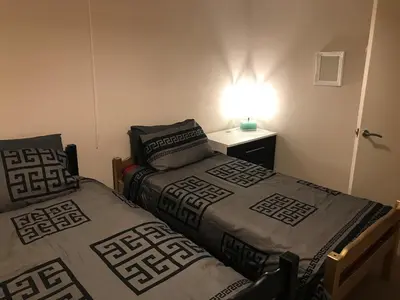 two beds in a room with a lamp on a table at 2 new bold lawns leamington spa in Moffat