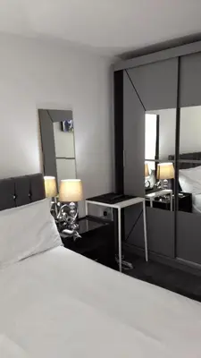 a bedroom with a bed and a desk and a mirror at Pazuri Apart in Moffat