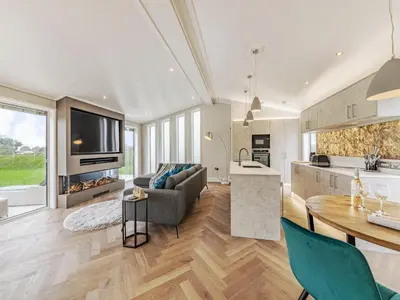 a kitchen and living room with a table and a couch at Landal North Lakes