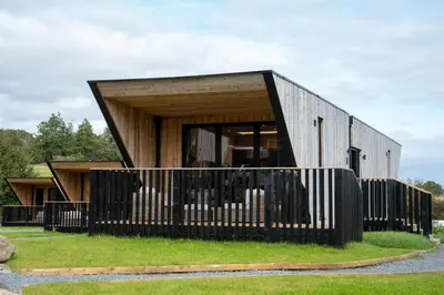 a house with a black fence in front of it at Landal Barnsoul in Shawhead