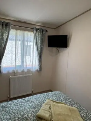 a bedroom with a bed and a television on the wall at Deblisa in Longtown