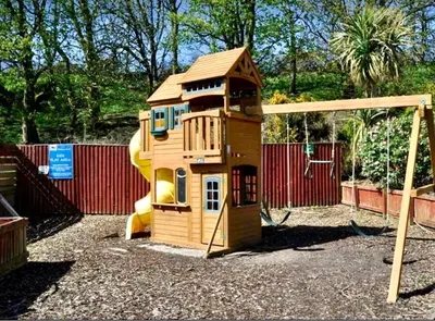 a small wooden play house with a slide at Loch View 28 in Stranraer