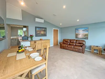 a kitchen and living room with a table and a couch at Grey Rocks Apartment in Kippford