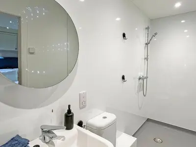 a white bathroom with a sink and a mirror at Grey Rocks Apartment in Kippford