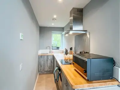 a kitchen with a counter with a sink and a stove at Grey Rocks Apartment in Kippford