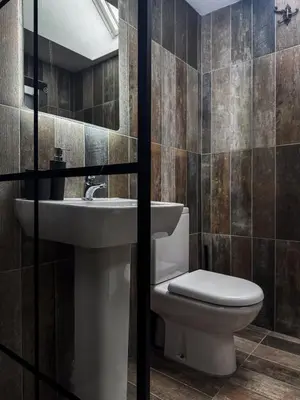 a bathroom with a toilet and a sink at Pink Cottage in Kirkcowan
