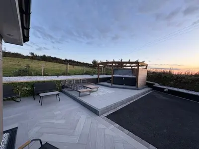 a patio with a bench and a gazebo at Woodway Lodge in Dumfries