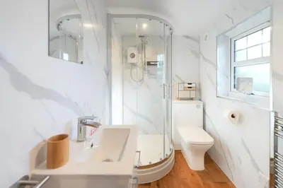 a white bathroom with a sink and a toilet at Lily Wood Cottage outside Hurlford in Hurlford
