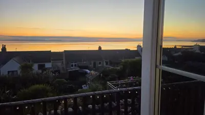 a view of a sunset from a balcony at Ocean View in Port William