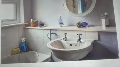a bathroom with a sink and a tub and a mirror at Ocean View in Port William