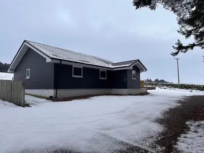 a blue house with snow in front of a driveway at Woodlane 3bedroom7 seater hottub and a pool table in Beeswing