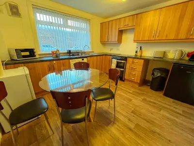 a kitchen with a glass table and chairs in it at Ayr 2 bed apartment in Ayr
