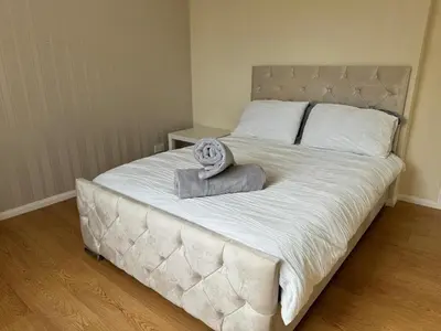 a large white bed with a statue on top of it at Ayr 2 bed apartment in Ayr