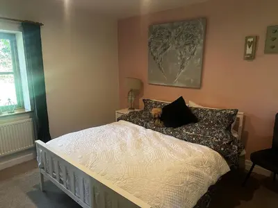 a bedroom with a bed with a teddy bear on it at The Dairy in Moffat