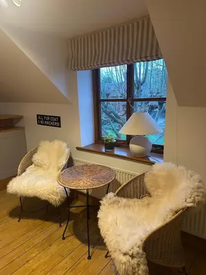 a living room with two chairs and a table and a window at The Dairy in Moffat