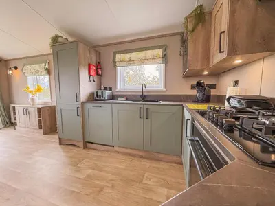 a kitchen with green cabinets and a counter top at Hornbeam Lodge in Bassenthwaite