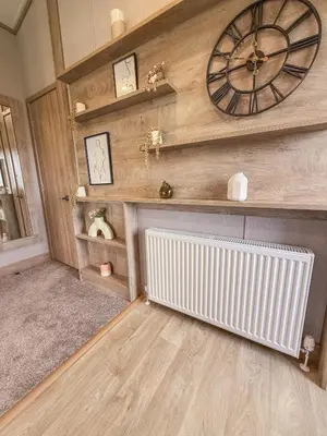 a room with a radiator and a clock on the wall at Hornbeam Lodge in Bassenthwaite