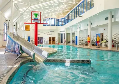 a swimming pool with a slide in a building at Stanwix Park in Silloth