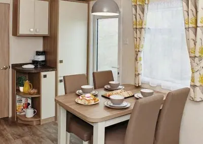 a dining room with a wooden table and chairs at Stanwix Park in Silloth