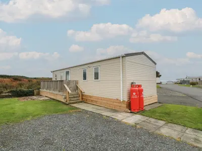 a mobile home with a red fire hydrant next to a road at Peaceful in Stranraer