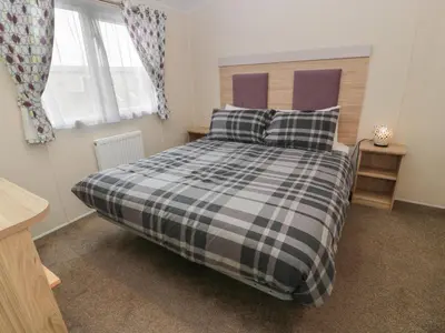 a bedroom with a black and white bed with pillows at Peaceful in Stranraer