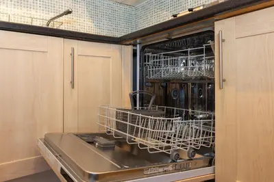a dishwasher with dishes in it in a kitchen at North Loft a Modern Apartment in Cockermouth in Cockermouth