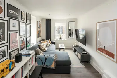 a living room with a couch and a tv at 1 Bed Flat in Shoreditch near Station by Hostroo in Moffat