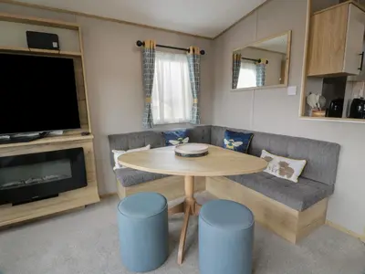 a living room with a table and a couch and a tv at Ellies House in Stranraer