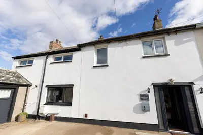 a white house with its door open on a street at EASTCOTE FARM - Spacious 5-Bed Home with Views, Garden & Playroom in Silloth