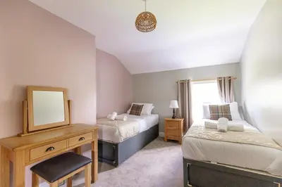 a small bedroom with two beds and a mirror at EASTCOTE FARM - Spacious 5-Bed Home with Views, Garden & Playroom in Silloth