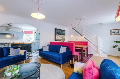 a living room with blue couches and a table at Springholm Cottage Family Retreat - Sleeps 10 in Bootle