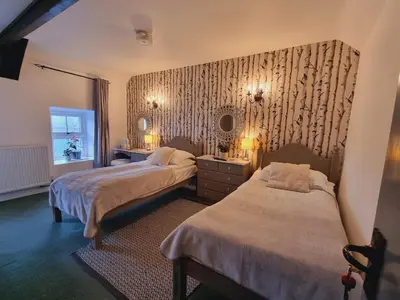 a hotel room with two beds and a mirror at Lane Head Farm Country Guest House in Troutbeck