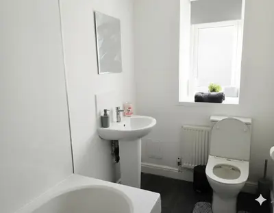 a white bathroom with a toilet and a sink at Esk View House in Carlisle