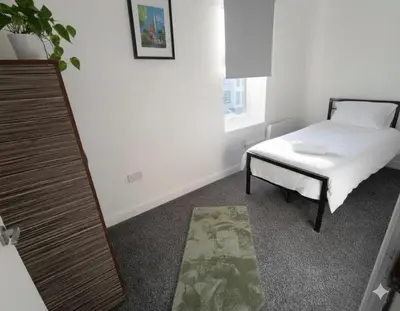 a bedroom with a bed and a table and a mirror at Esk View House in Carlisle