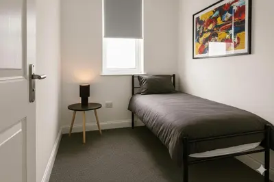 a small bedroom with a bed and a small table at Esk View House in Carlisle