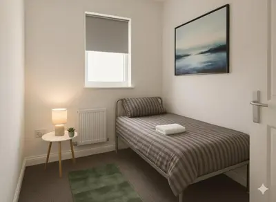 a small bedroom with a bed and a window at Esk View House in Carlisle