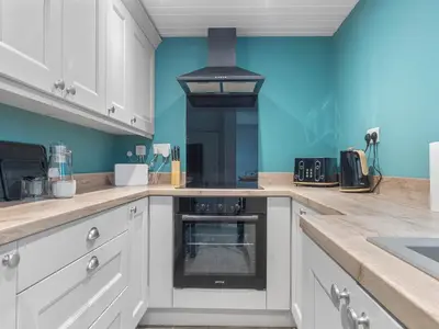 a kitchen with white cabinets and a stove at Harrington Haven - 4bed Home Workington in Workington