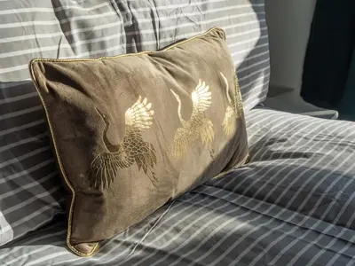 a brown pillow with two birds on a bed at Harrington Haven - 4bed Home Workington in Workington
