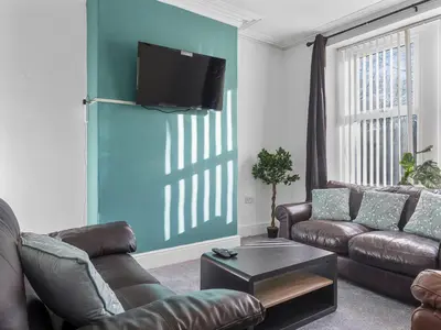 a living room with a couch and a tv on a wall at Harrington Haven - 4bed Home Workington in Workington