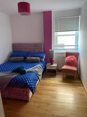 a bedroom with a bed and a chair and a window at Number one faraline in Moffat