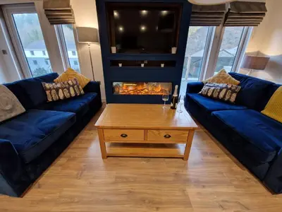 a living room with two blue couches and a coffee table at High Spy Luxury Lodge in Keswick